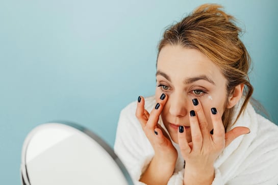 Women applying retinol under eyes