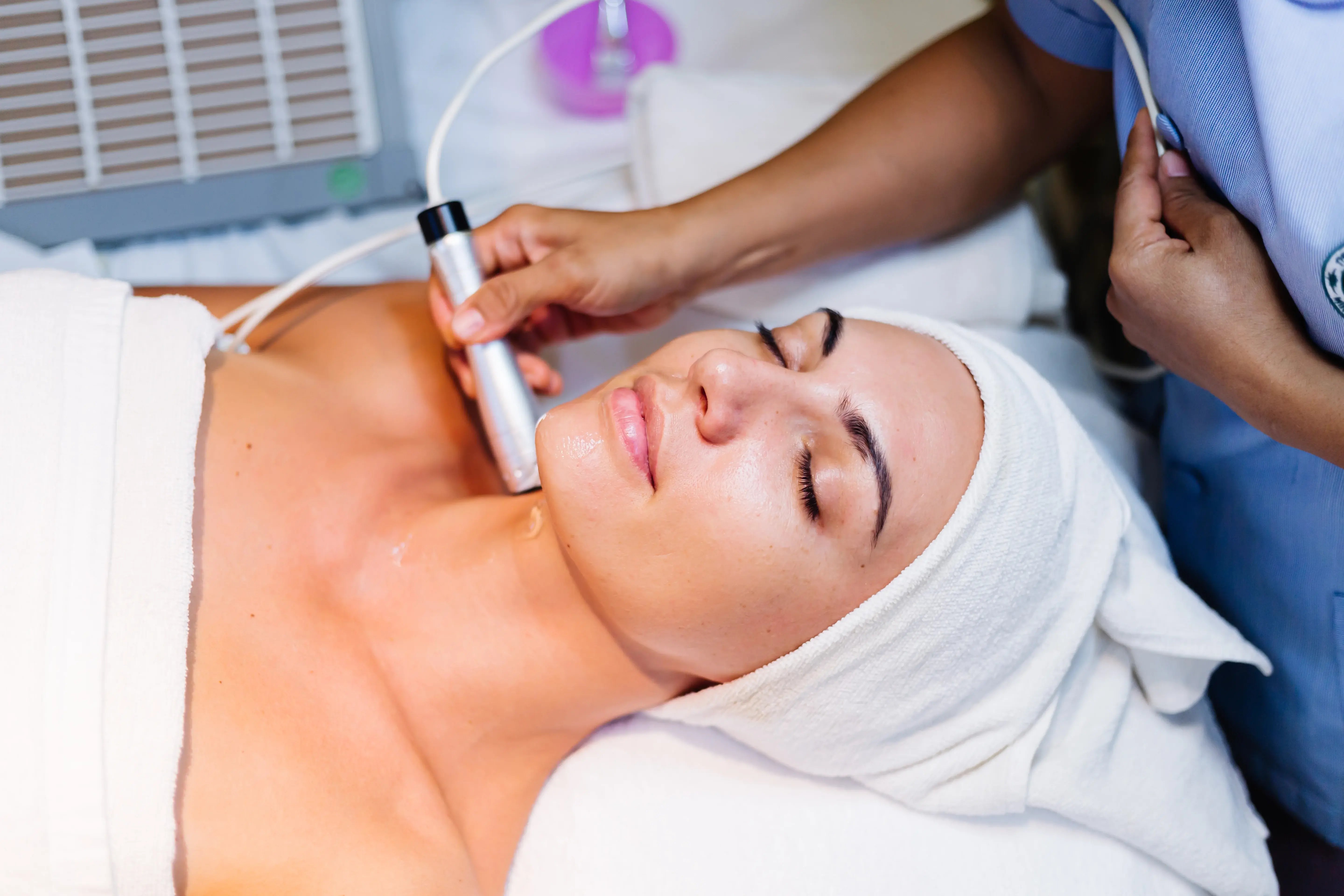 women laying down getting BBL laser treatment done on face and body